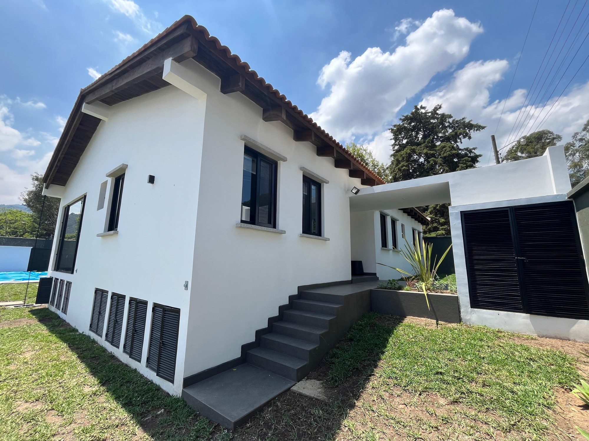 Sala de estar con vigas de madera y acceso a terraza — Casa San Pedro
