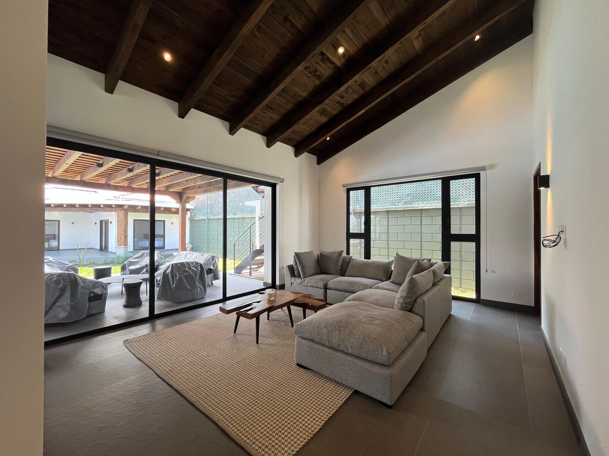 Comedor exterior bajo pérgola de madera — Casa San Pedro El Alto