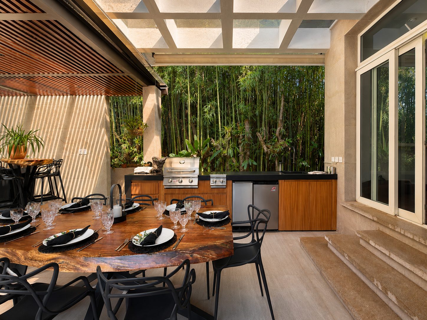Casa Santa Rosalía — comedor exterior con techo de vidrio y muro de bambú